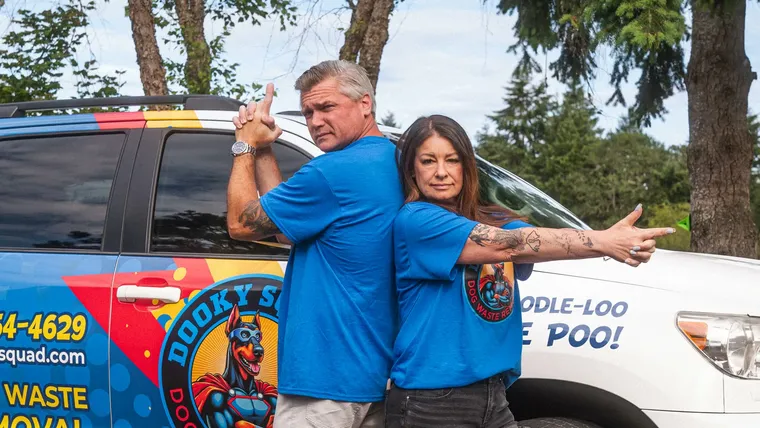 Marquis Pounds posing back to back with a Dooky Squad team member in front of the branded vehicle
