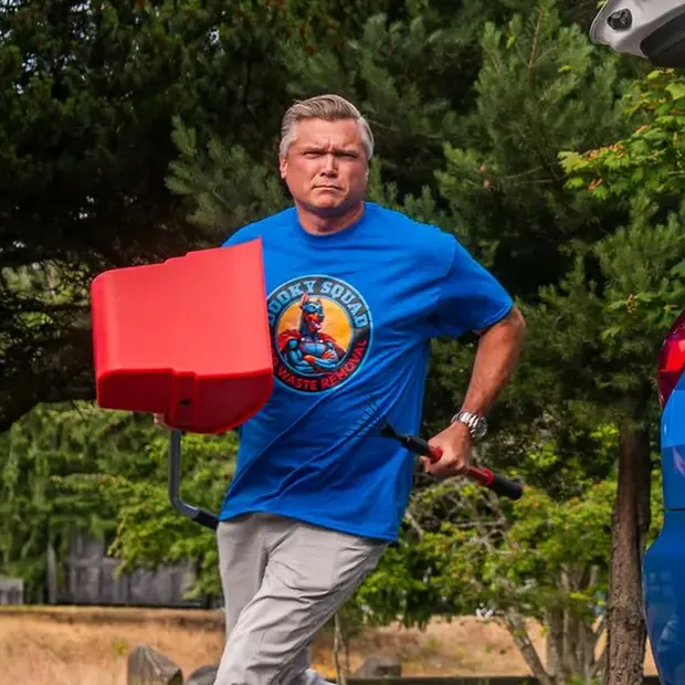 Marquis Pounds, founder of Dooky Squad, carrying a scooper and bin