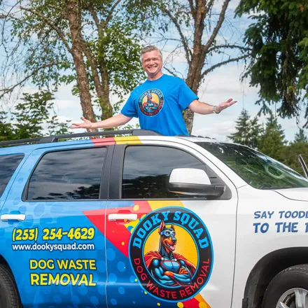 Marquis Pounds, founder of Dooky Squad, beside the branded company vehicle